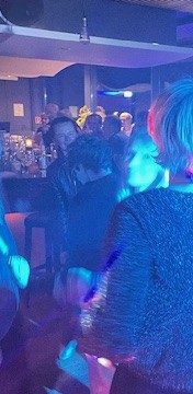 DJ Flemming Bunte Lichter und Menschen, die in einer lebhaften Atmosphäre tanzen.